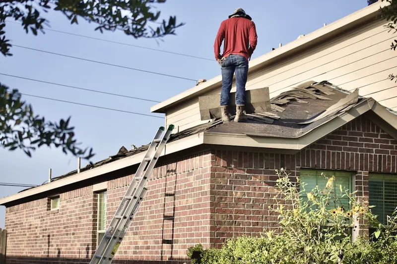 Professional roofer working on a residential roof in Rye